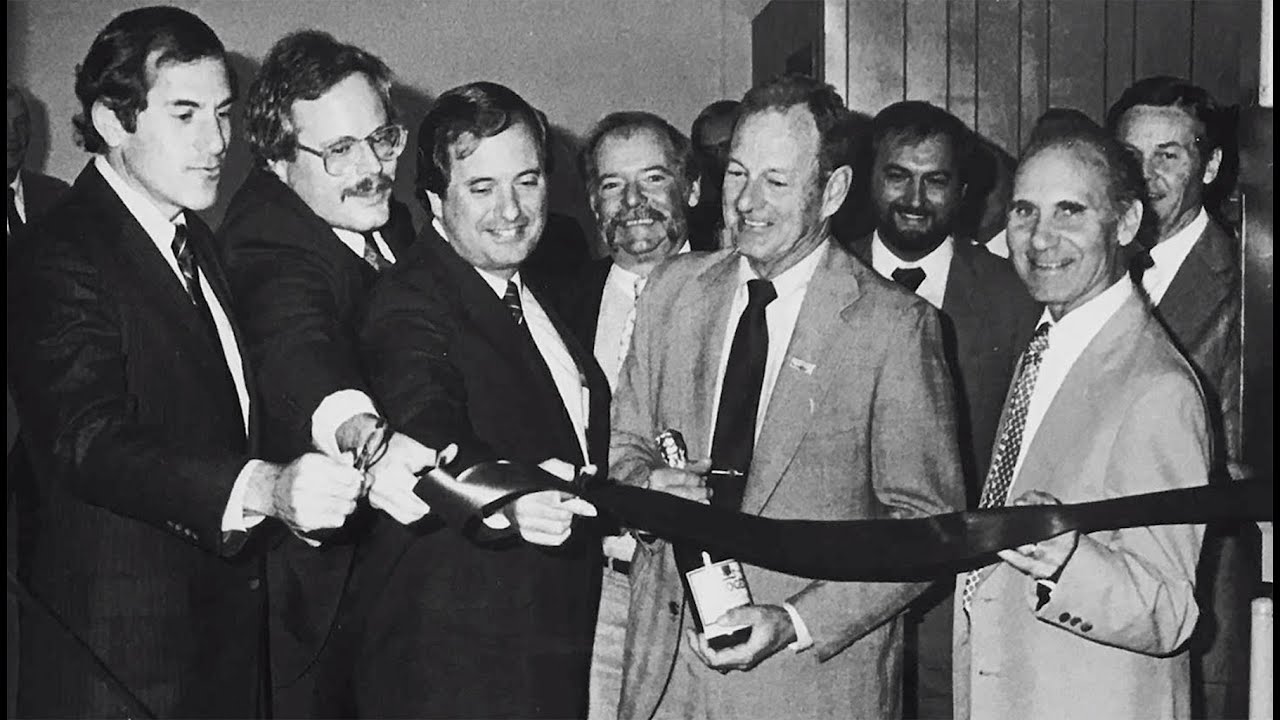 people cutting an opening day ribbon in black and white