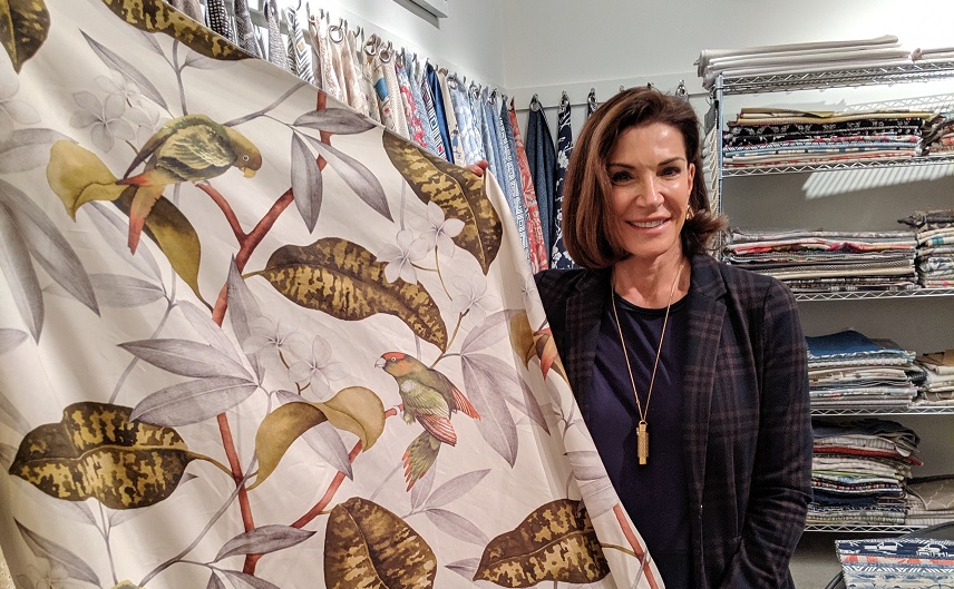Hilary Farr holding floral patterned fabric with birds on it 